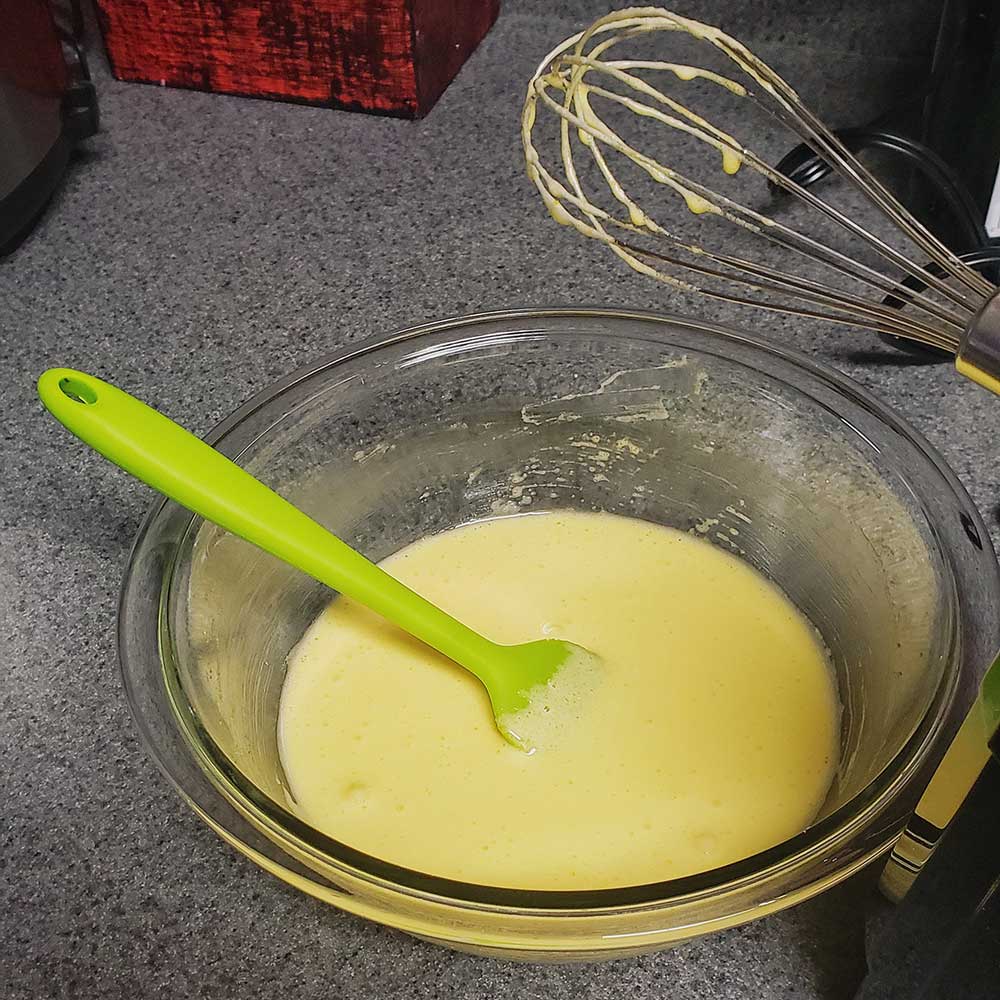 A cooking bowl with whisked egg yolks and granulated sugar.