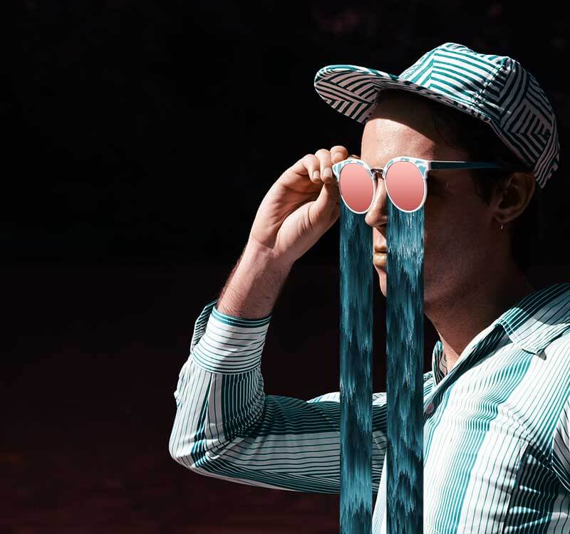 A man holding his glasses while pixels fall from under the lenses.