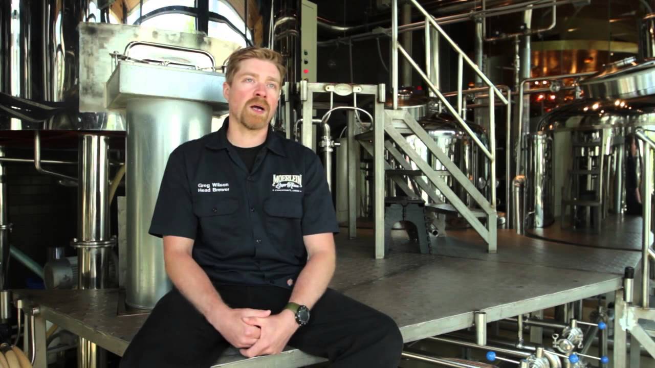Photo of a man sitting in a brewery talking about beer.